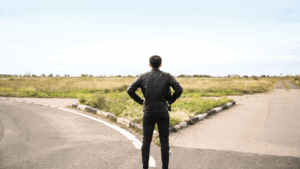 Man choosing over which path to take: the ACT or the SAT.