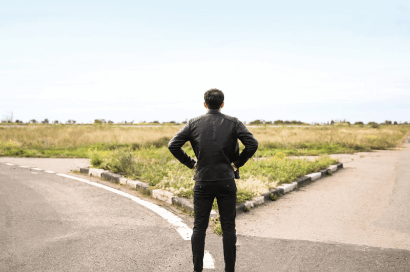 Man choosing over which path to take: the ACT or the SAT.