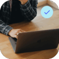 User on a laptop with check mark in the top right corner